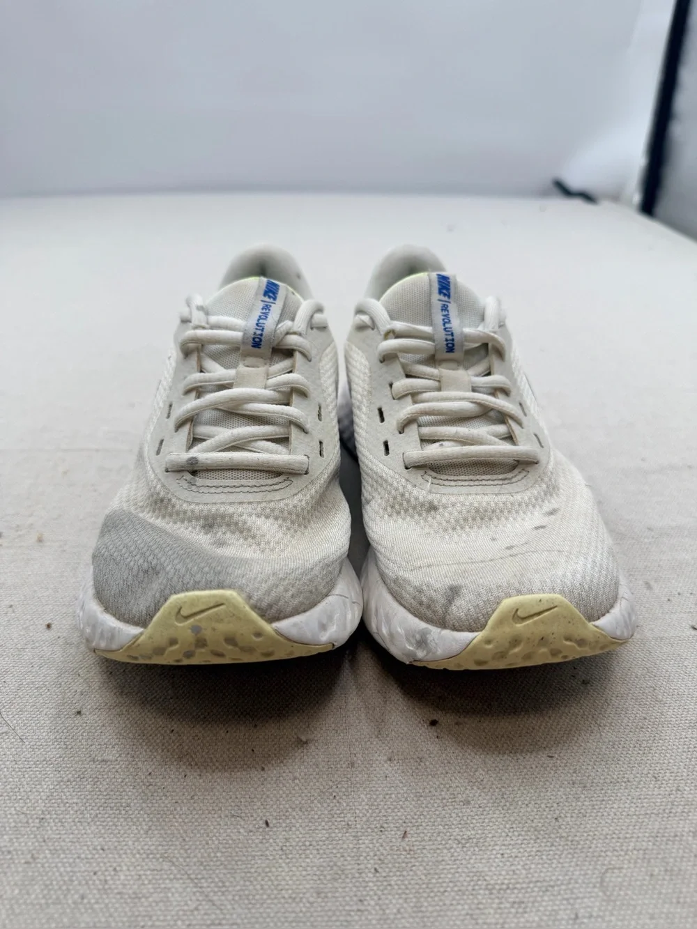 Nike Women’s Revolution Sneakers in Cream with Light Purple Swoosh